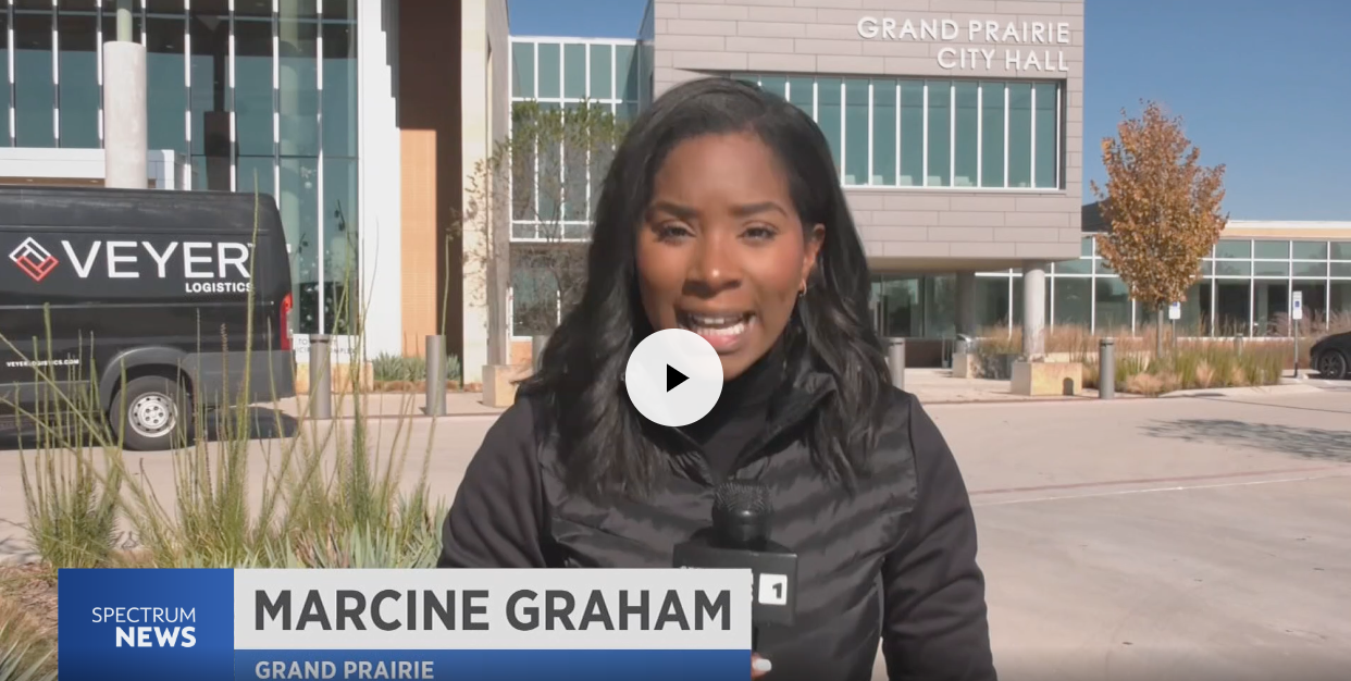 A reporter standing outside Grand Prairie City Hall speaks to the camera.